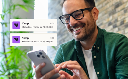 Mãos mexendo em um celular e acessando o app da Yampi.